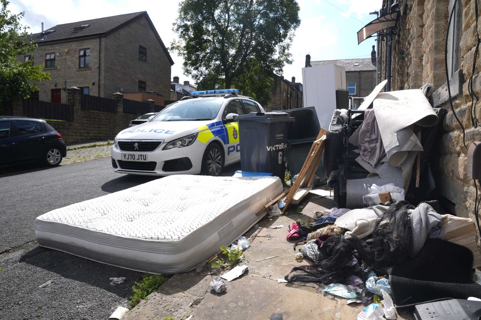 Police outside a house in Minnie Street, as West Yorkshire Police said a number of warrants were executed in the Keighley area of Bradford overnight in relation to the fatal fire on August 21