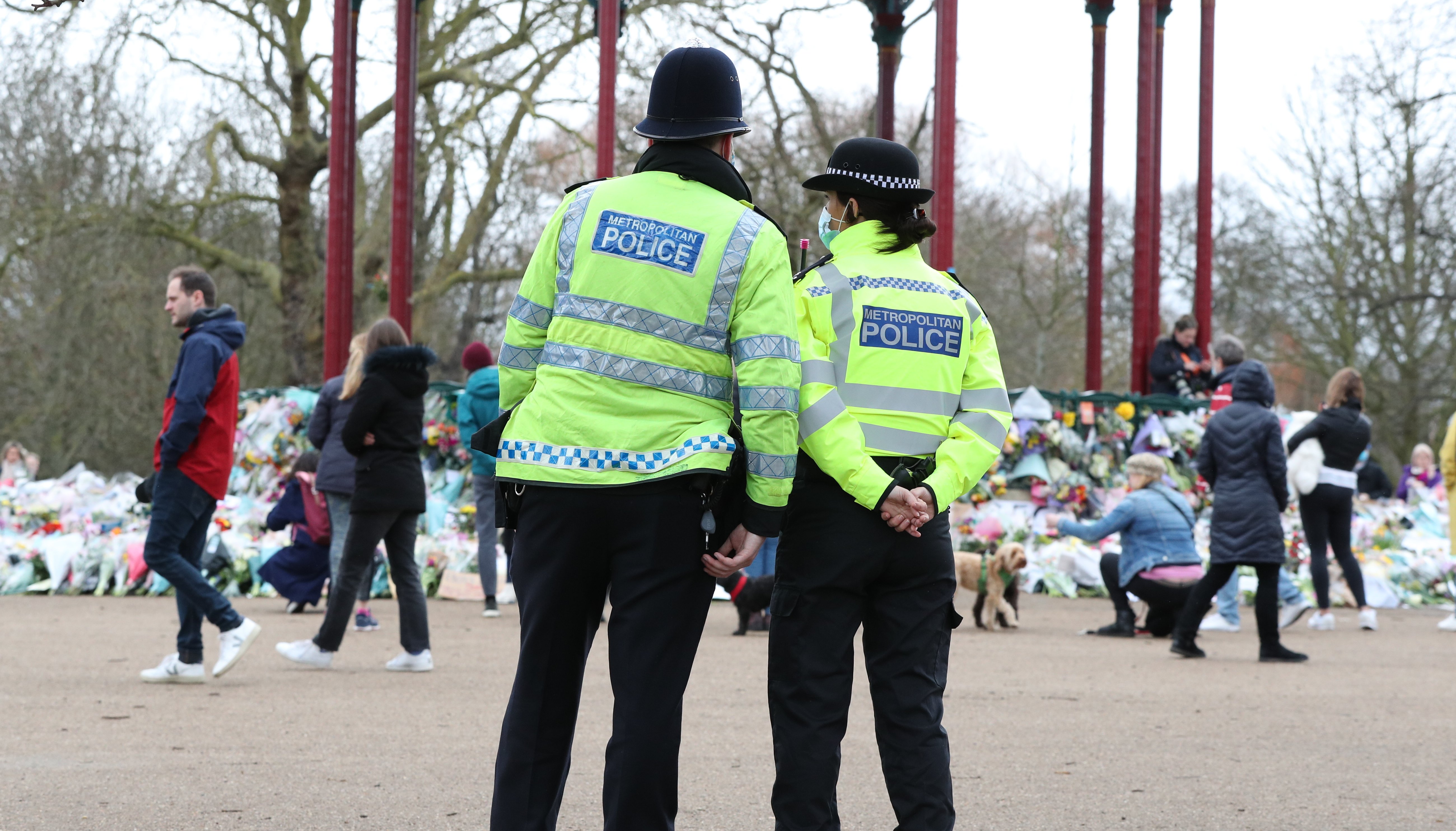 Police patrol near to floral tributes left at the bandstand in Clapham Common, London, for murdered Sarah Everard.