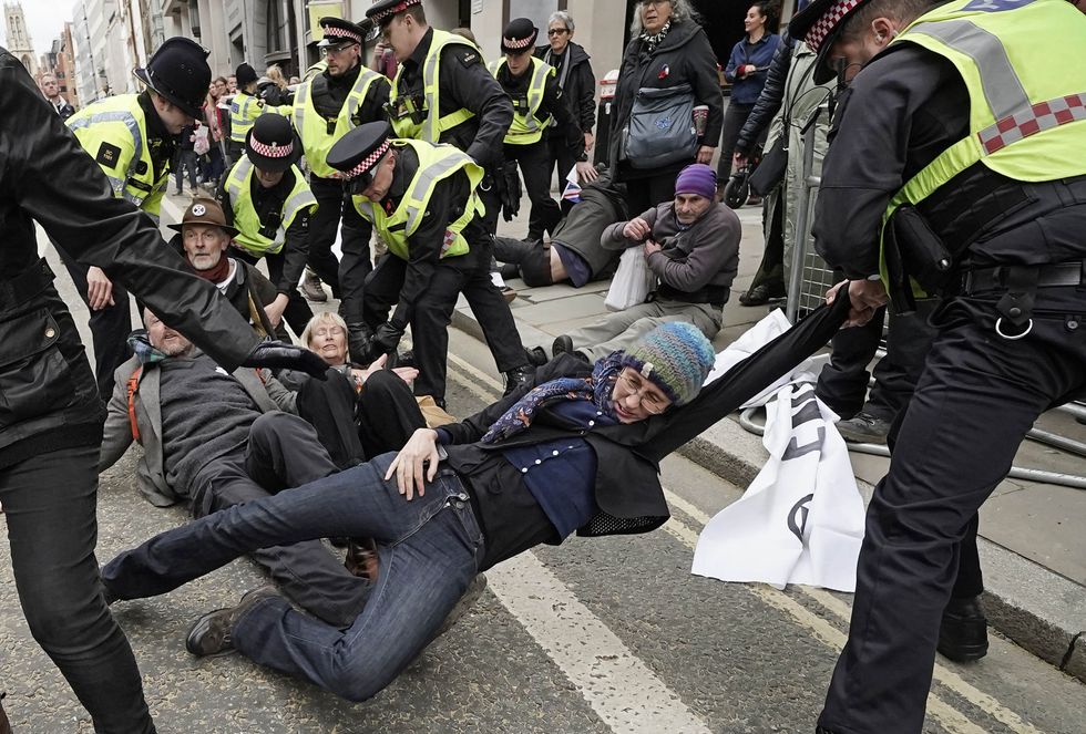 Police remove Extinction Rebellion protestors during the Lord Mayor's Show parade in the City of London.