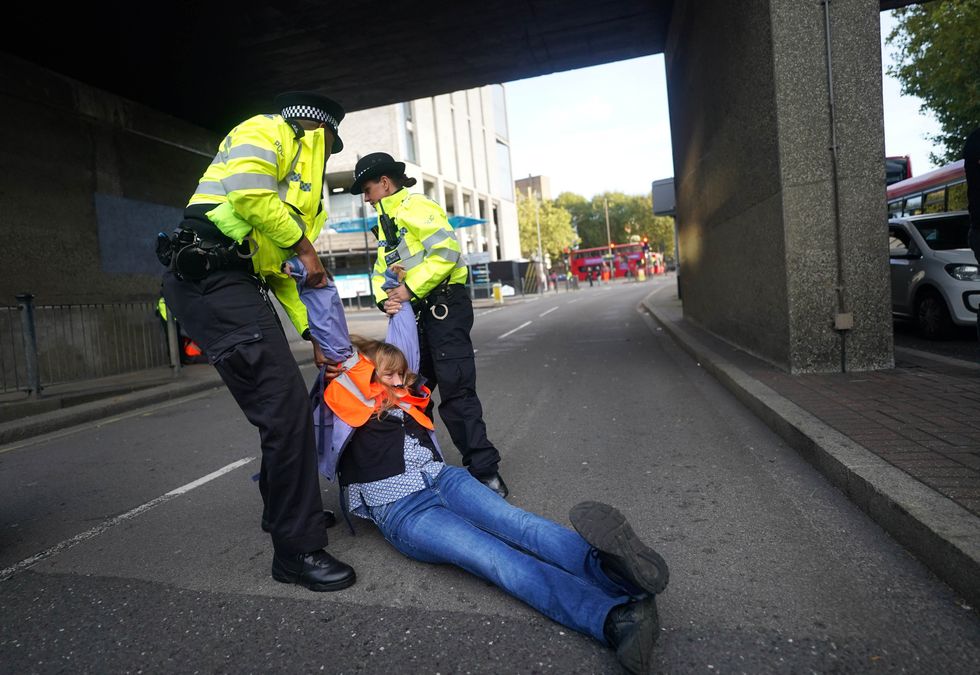 Police removing Insulate Britain protesters after they blocked a road near Canary Wharf in east London. Climate group Insulate Britain had pledged to restart its road-blocking protests despite the risk of its members being jailed or fined.