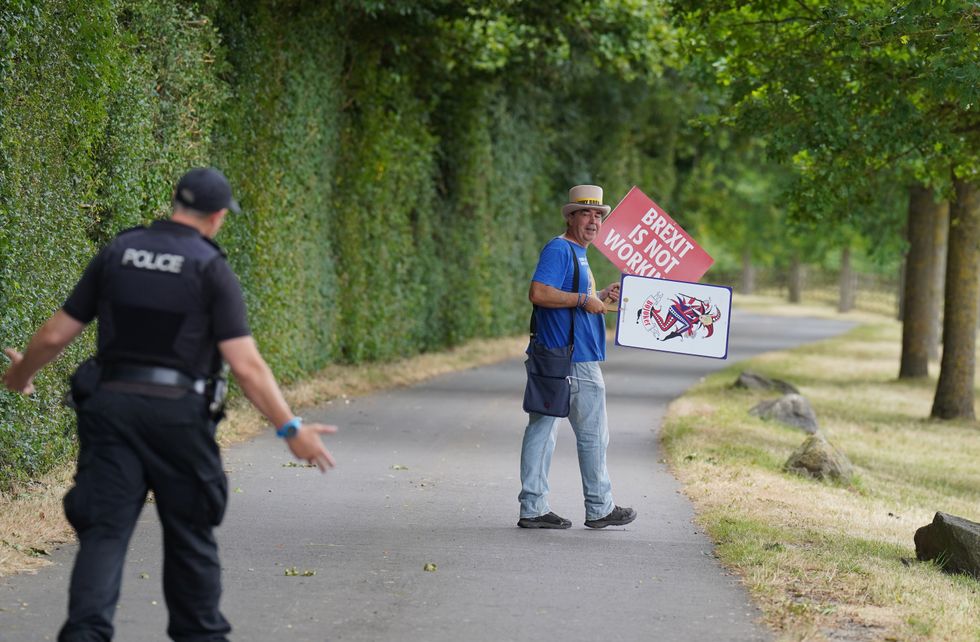 Police talk to protester Steve Bray as he demonstrates near Daylesford House in Gloucestershire, where Prime Minister Boris Johnson and wife Carrie are holding a first wedding anniversary party for friends and family. Picture date: Saturday July 30, 2022.