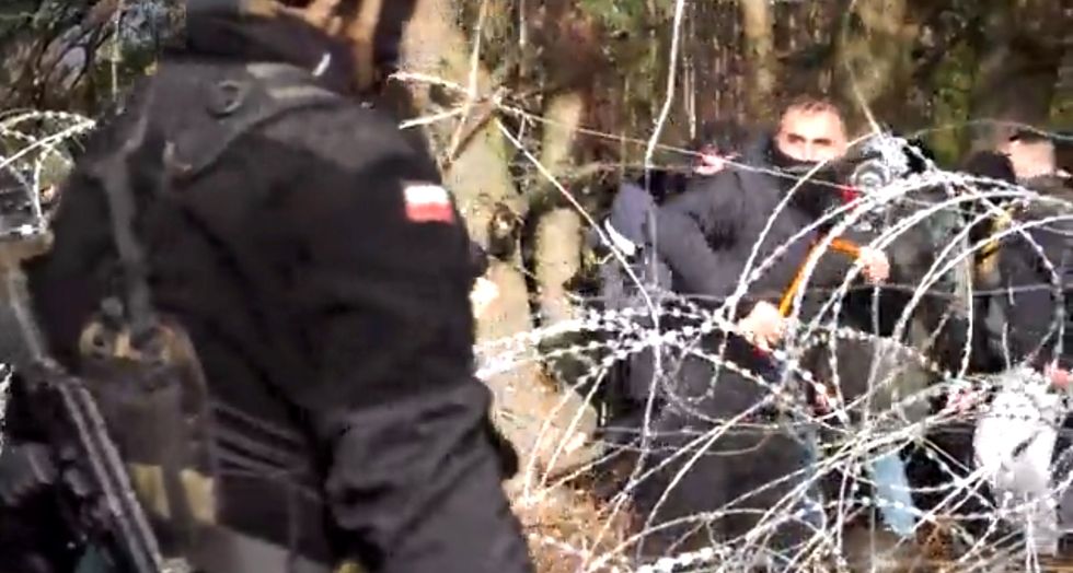 Polish police and border guard block hundreds of migrants who try to cross from the Belarus side of the border with Poland near Kuznica Bialostocka, Poland, in this video-grab released by the Polish Defence Ministry, November 8, 2021. MON/Handout via REUTERS THIS IMAGE HAS BEEN SUPPLIED BY A THIRD PARTY