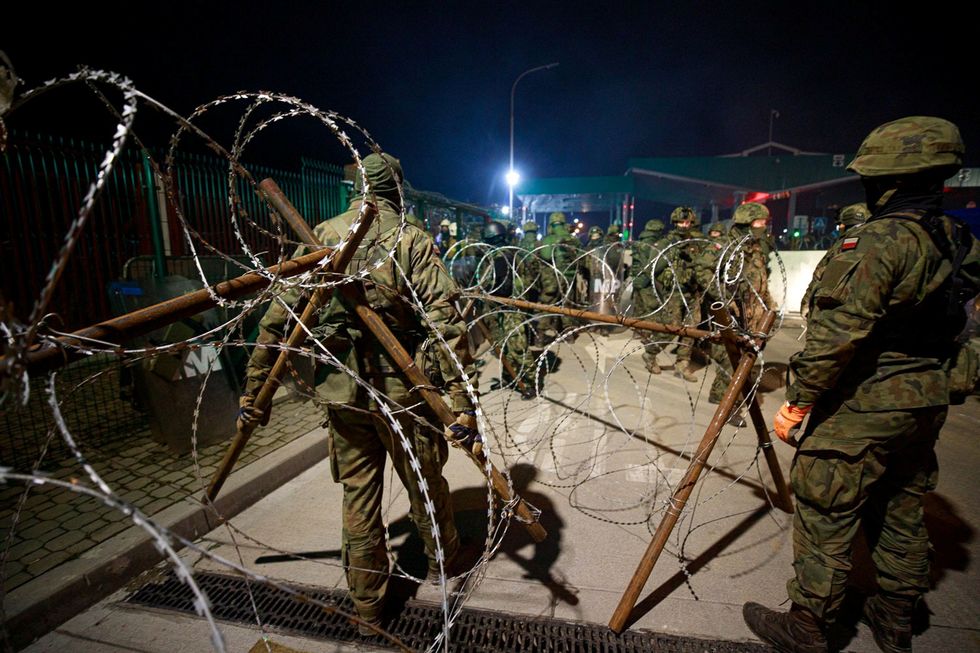 Polish Territorial Defence Forces build additional razor wire fence where hundreds of migrants camp at the Belarus side of Kuznica Bialostocka-Bruzgi border crossing