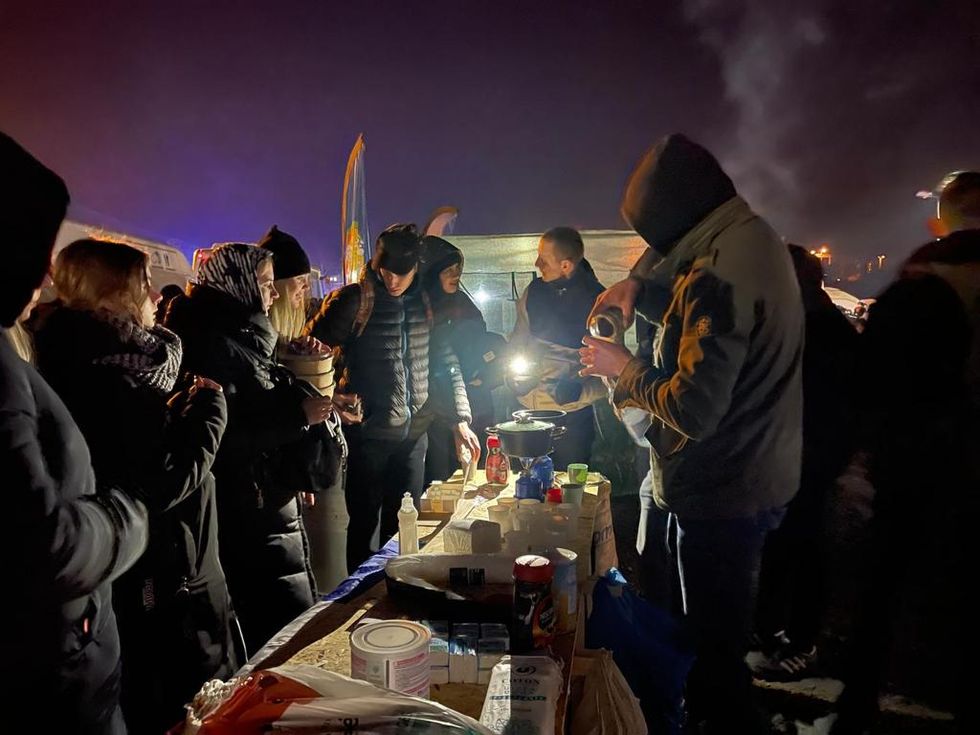 Polish volunteers serve tea and coffee to refugees coming across the border from Ukraine