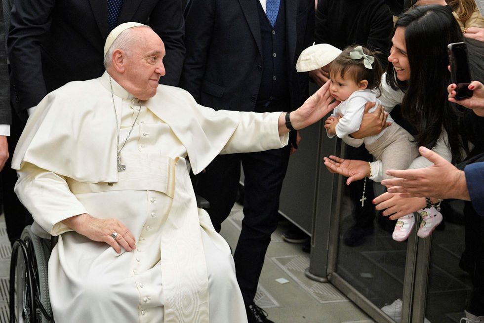 Pope Francis looks at a child during the weekly general audience at the Vatican, January 25, 2023. Vatican Media/\u00adHandout via REUTERS ATTENTION EDITORS - THIS IMAGE WAS PROVIDED BY A THIRD PARTY.