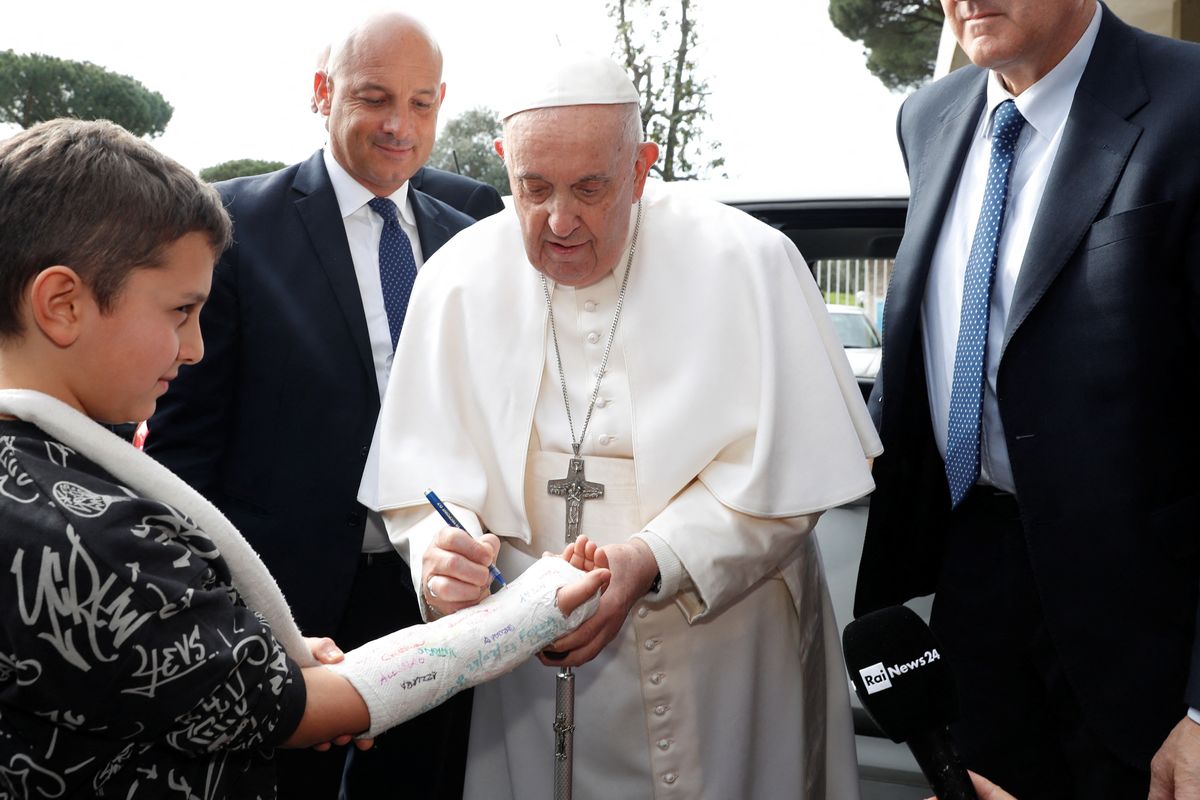 Pope Francis signing a boy's cast