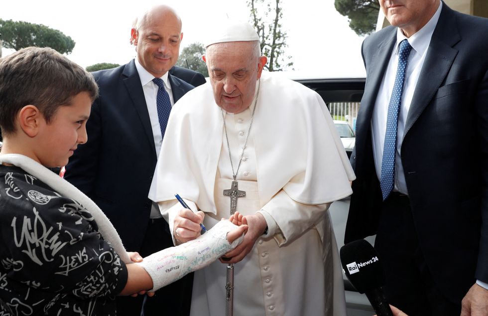 Pope Francis signing a boy's cast