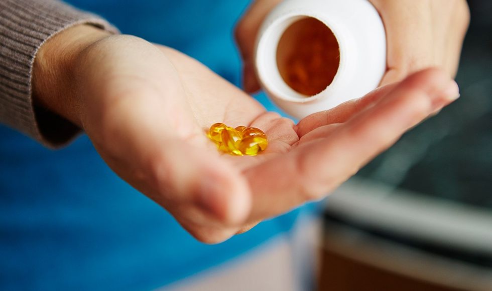 Pouring vitamin D supplements into hand