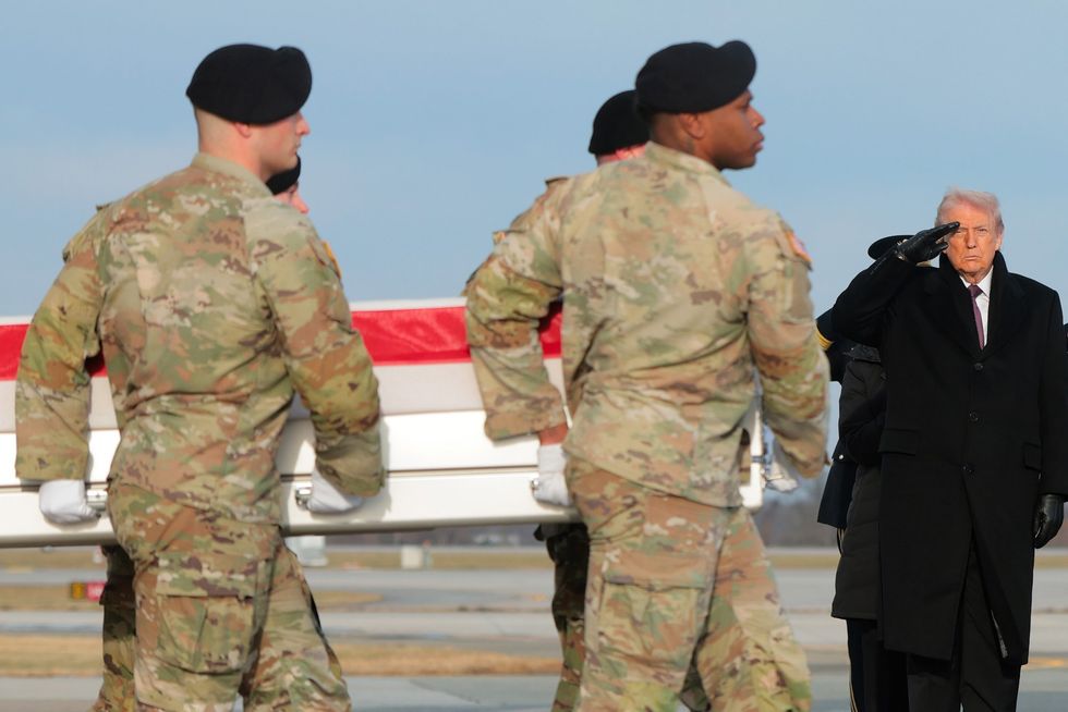 President Donald Trump saltues coffins of US personnel killed in Syria