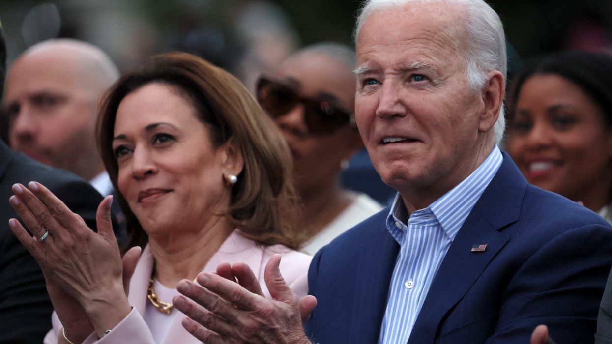 President Joe Biden claps hands next to Vice-President Kamala Harris