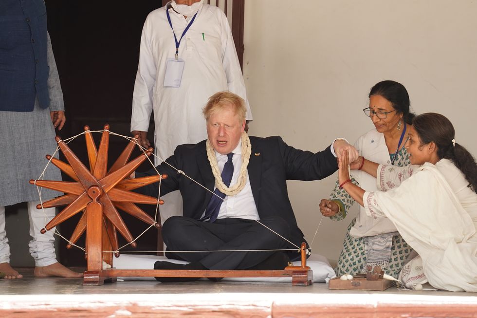 Prime Minister Boris Johnson is show how to operate a cotton wheel at Mahatma Gandhi's house at the Sabarmati Ashram in Ahmedabad during a cultural tour as part of his two day visit to India. Picture date: Thursday April 21, 2022.