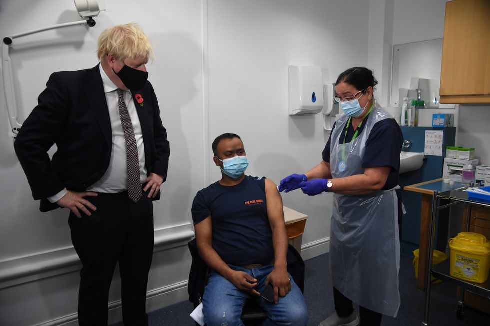 Prime Minister Boris Johnson meeting Arzou Miah, who received his booster jab on Monday, during his visit to Woodgrange GP Surgery vaccination centre in east London to meet staff and see people receiving their booster vaccines. Picture date: Monday November 15, 2021.