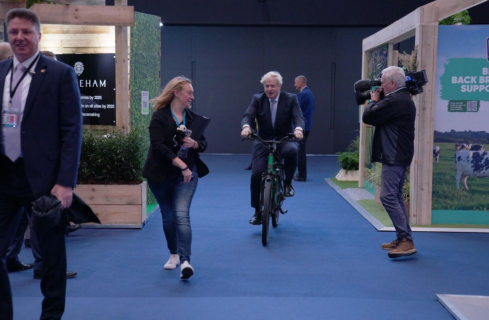 Prime Minister Boris Johnson on a bicycle in the Manchester Central Convention Complex during the Conservative Party Conference in Manchester. Picture date: Tuesday October 5, 2021.