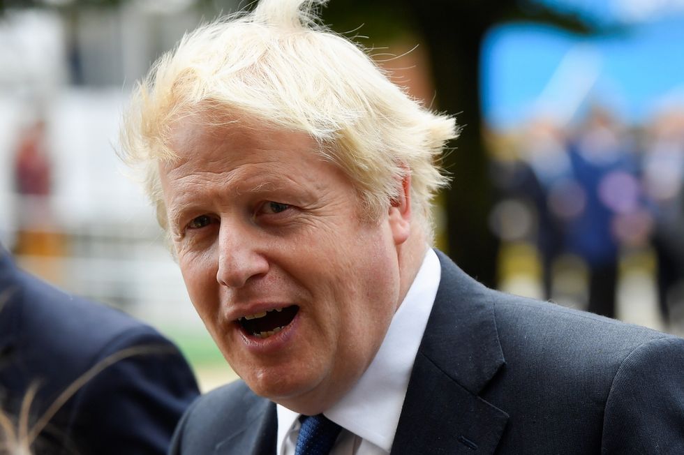 Prime Minister Boris Johnson walks outside the hotel during the annual Conservative Party conference, in Manchester