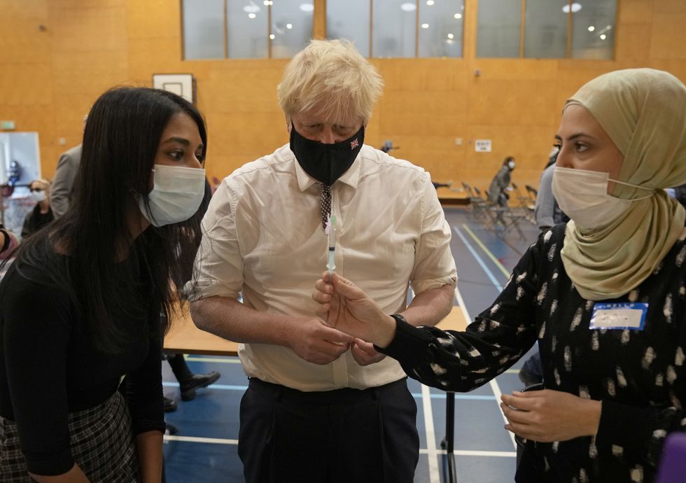 Prime Minister Boris Johnson watches as a dose of the pfizer vaccine is diluted before being administered, during a visit to the Covid-19 vaccine centre at the Little Venice Sports Centre in west London.