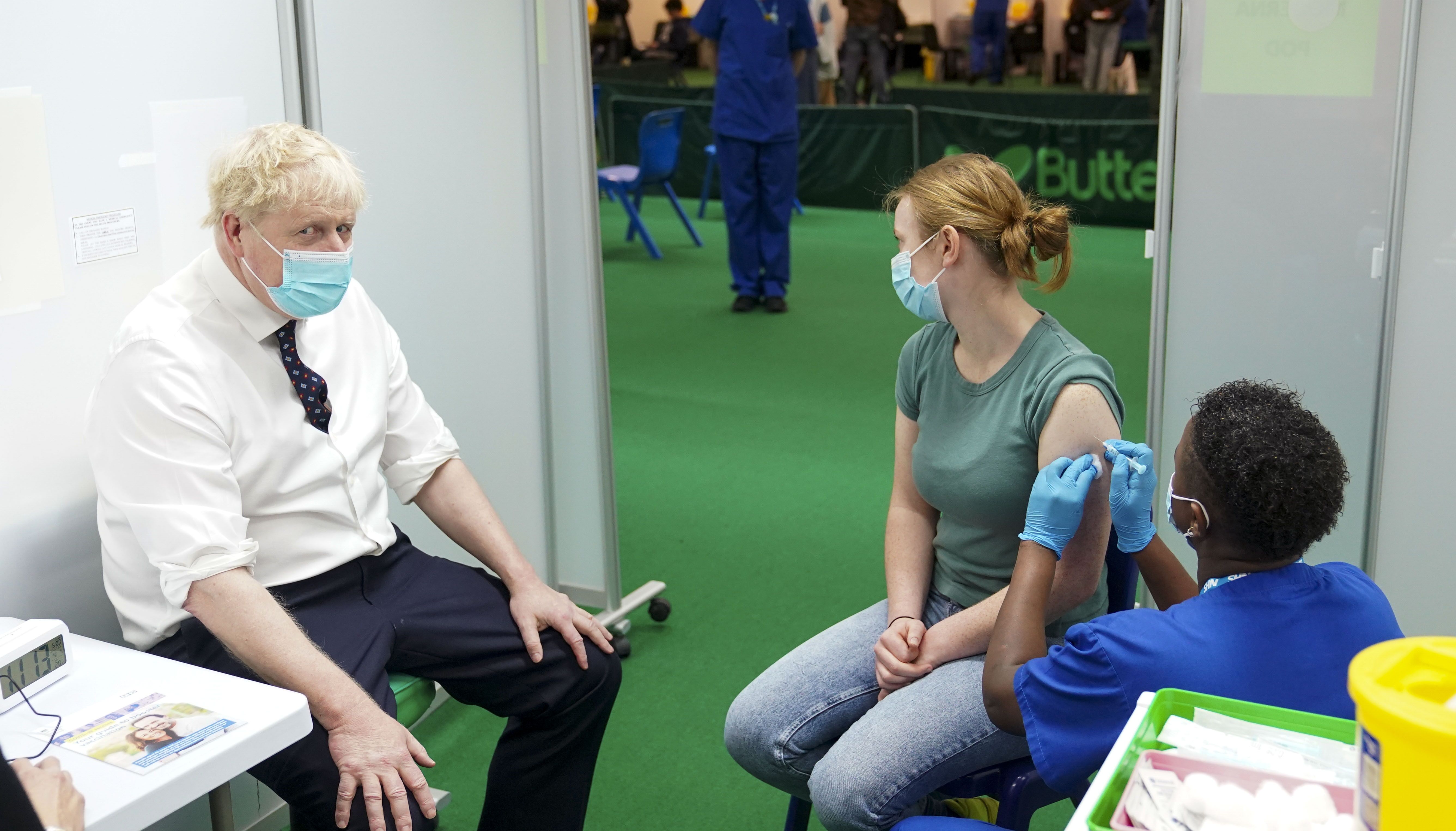 Prime Minister Boris Johnson watches as Esther (surname not given), 19, receives her Covid-19 booster vaccine during a visit to a vaccination hub in the Guttman Centre at Stoke Mandeville Stadium in Aylesbury, Buckinghamshire, as the booster vaccination programme continues.