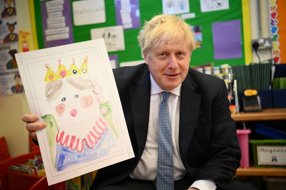 Prime Minister Boris Johnson with the portrait he painted of the Queen during a drawing session with children as part of a visit at the Field End Infant school, in South Ruislip