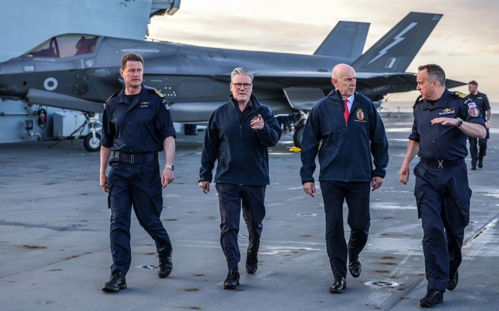 Prime Minister Keir Starmer (2L) and Britain's Defence Secretary John Healey (2R) talk with Royal Navy Vice Admiral Andrew Burns (L) and Commodore James Blackmore