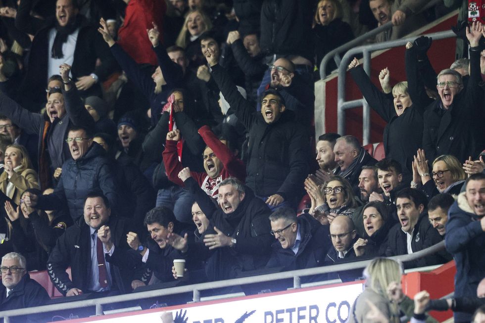 Prime Minister Rishi Sunak, a Southampton fan, gets to his feet and punches the air after Carlos Alcaraz of Southampton scores