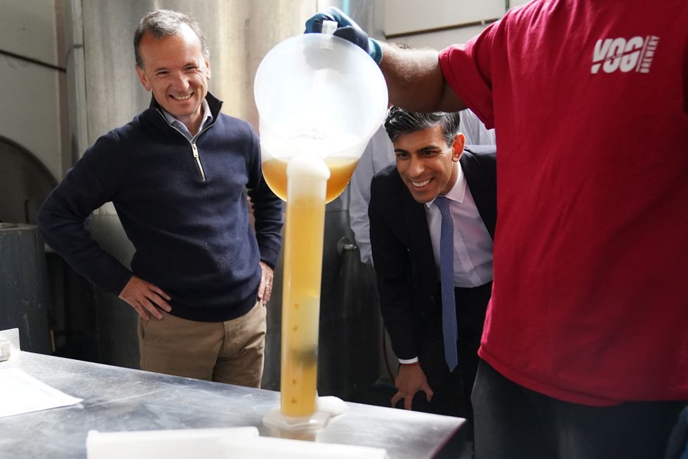 Prime Minister Rishi Sunak and MP for Vale of Glamorgan Alun Cairns (left) watching beer production at the Vale of Glamorgan Brewery, in Barry