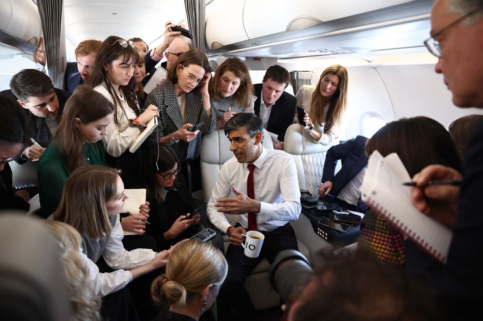 Prime Minister Rishi Sunak speaks to journalists on board a plane on his way to Warsaw