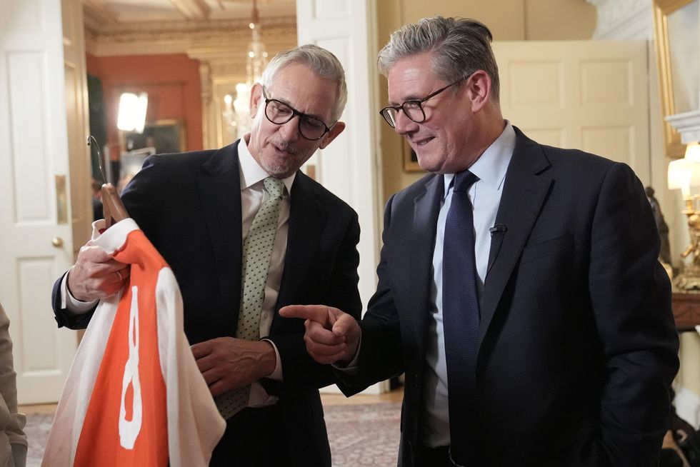 Prime Minister Sir Keir Starmer and Gary Lineker looking at a football shirt during a reception to celebrate St George's Day