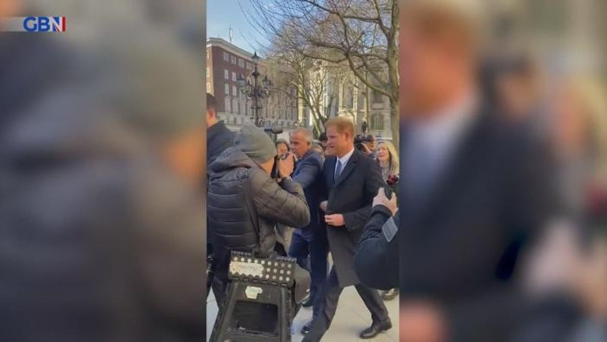 Prince Harry walks into photographer as he arrives at High Court for legal battle