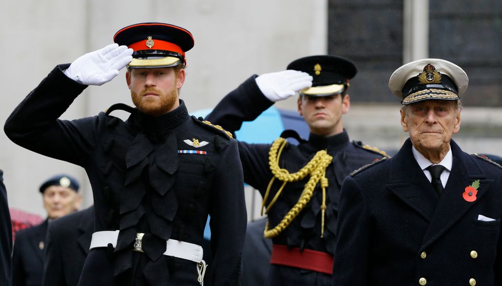 Prince Harry salutes next to the Duke of Edinburgh during the opening of the Field of Remembrance at Westminster Abbey in London.