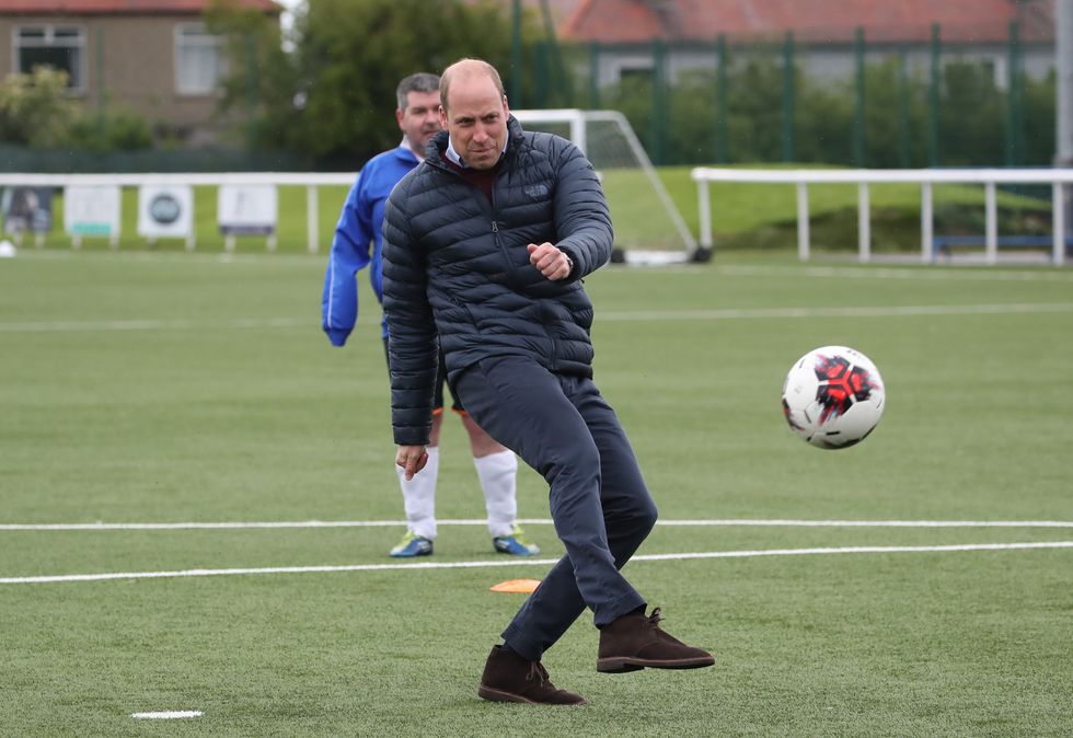 Prince William kicking a football