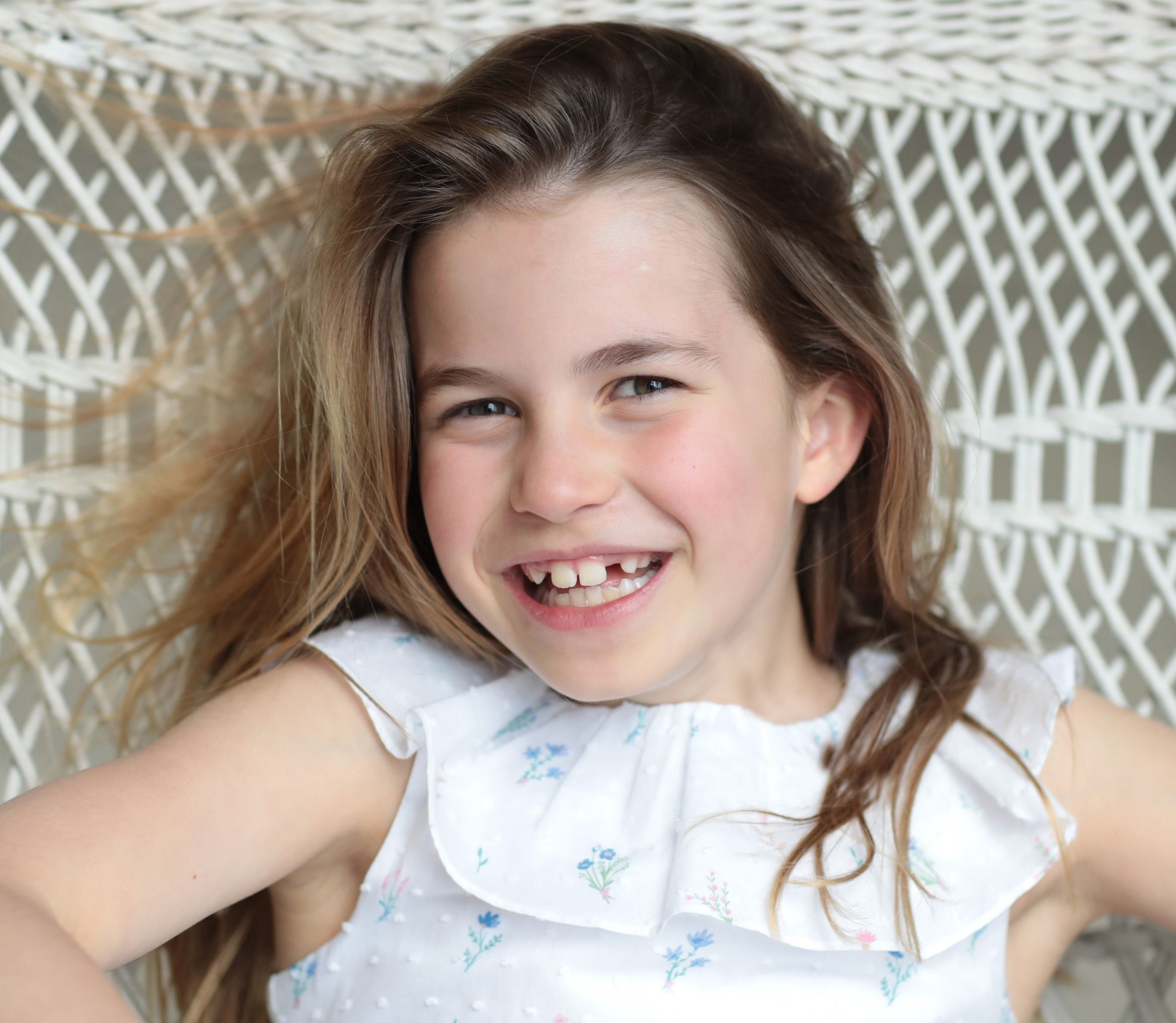 Princess Charlotte smiling in a white dress