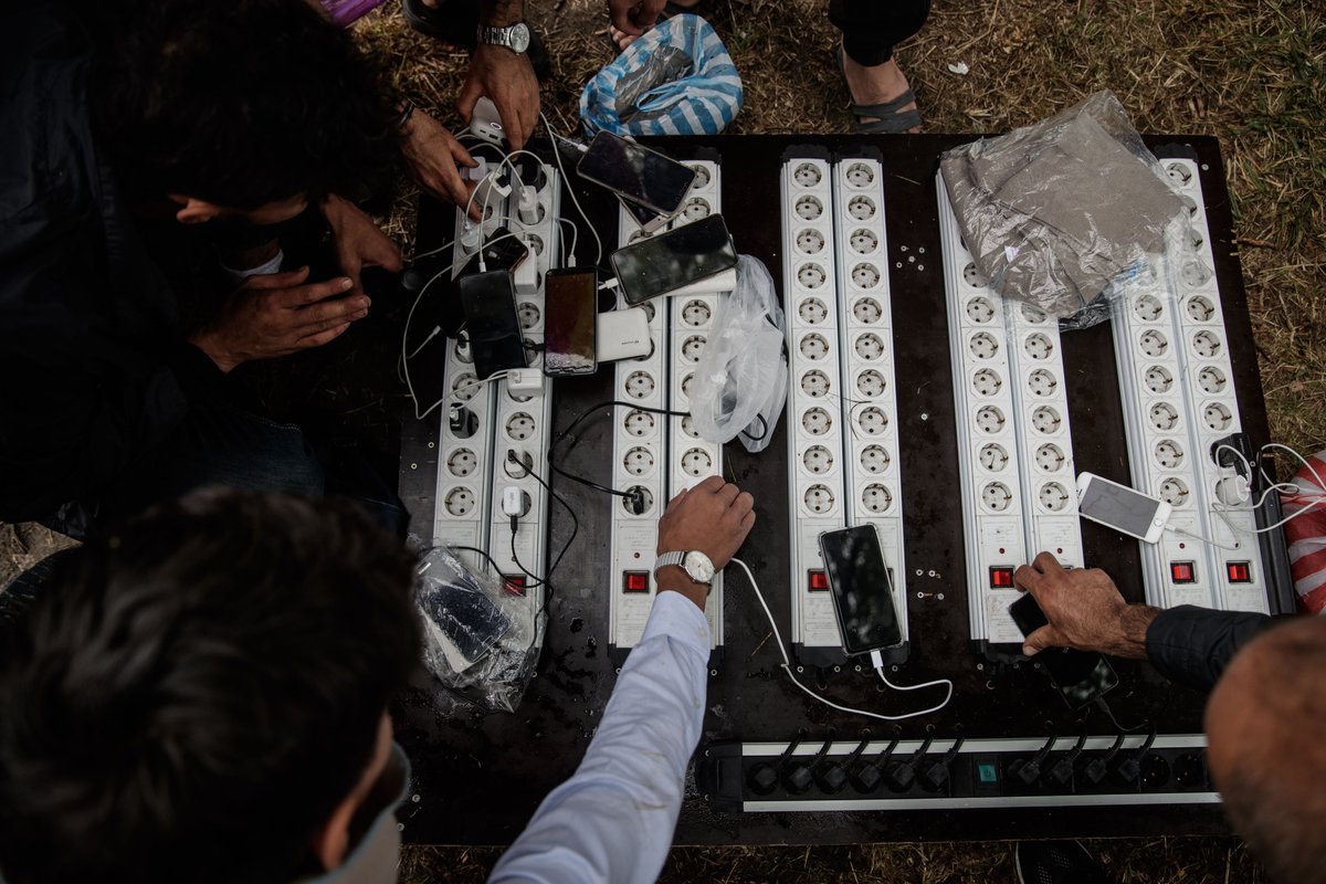 Prospective migrants charge up their phones before crossing the Channel