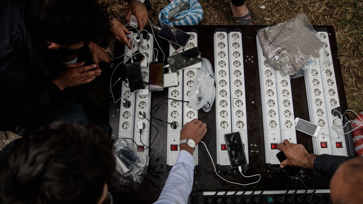 Prospective migrants charge up their phones before crossing the Channel