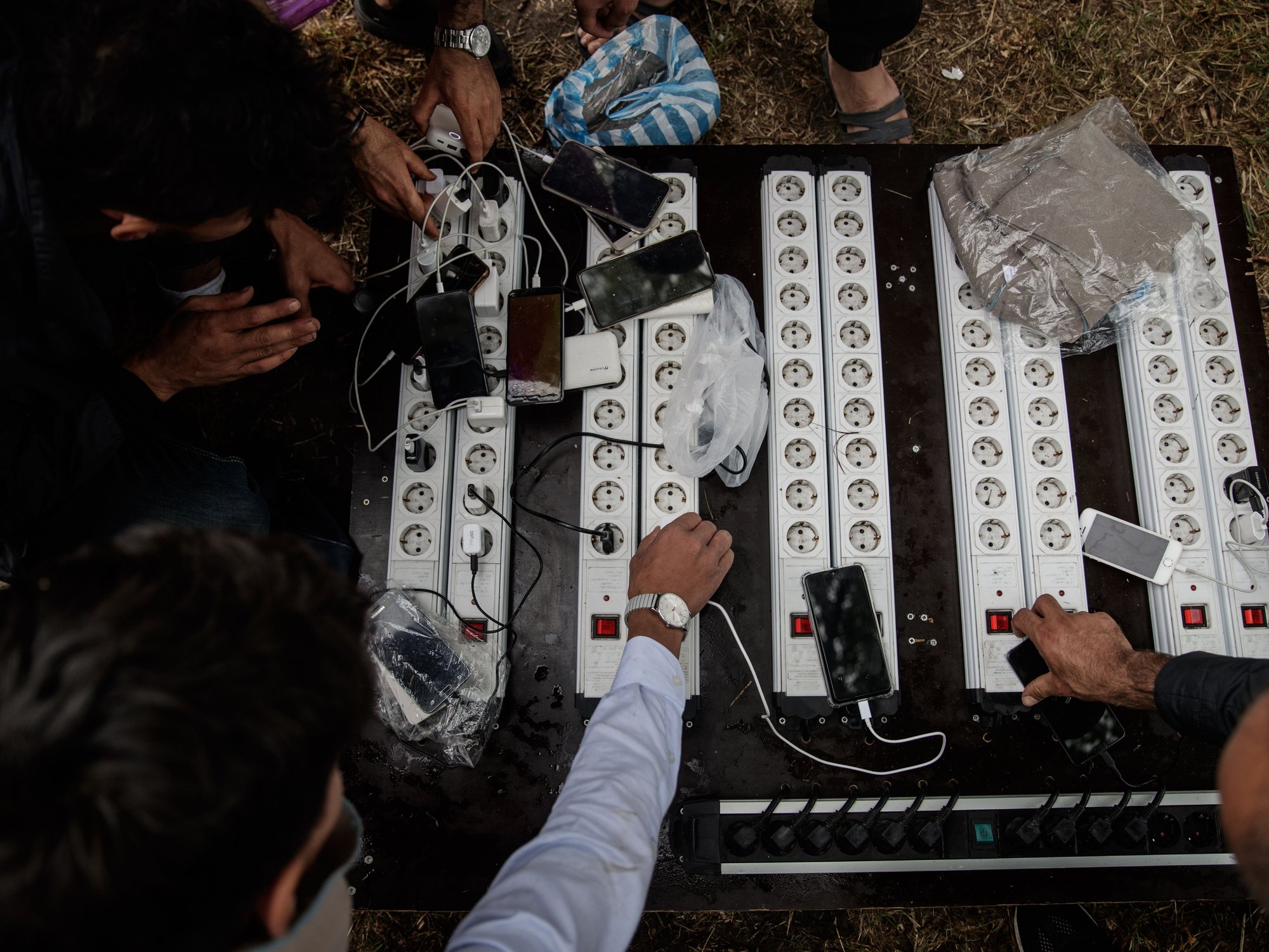 Prospective migrants charge up their phones before crossing the Channel