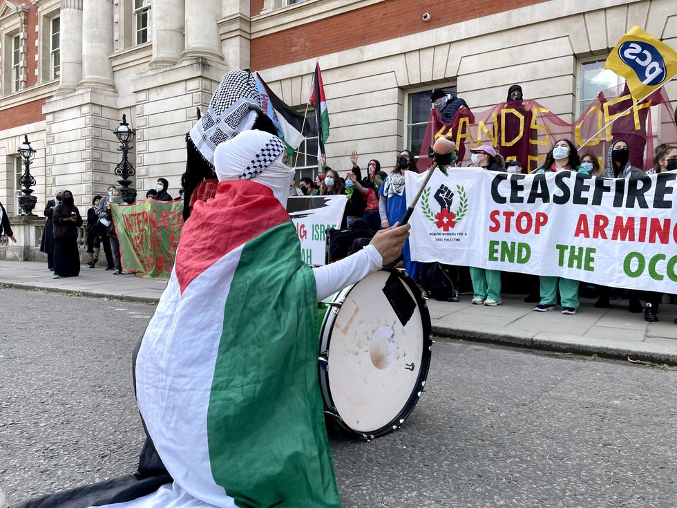 Protester banging a drum outside the Department for Business and Trade