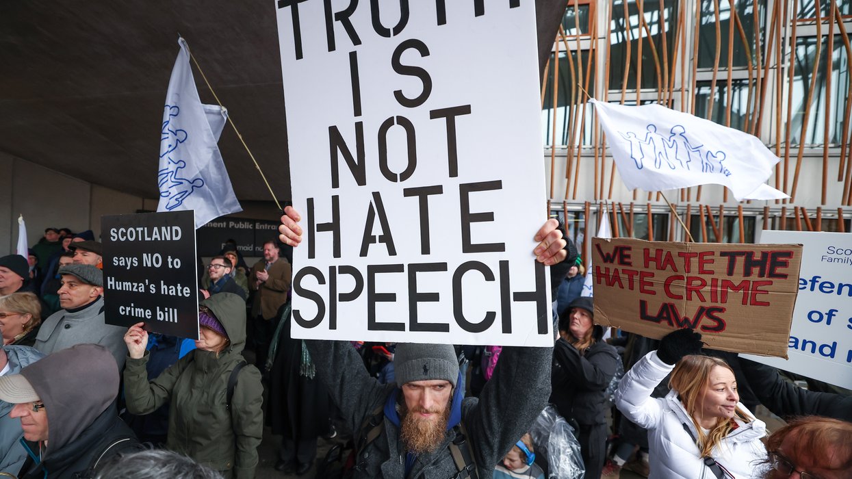 Protester holds up poster reading 'truth is not hate speech'