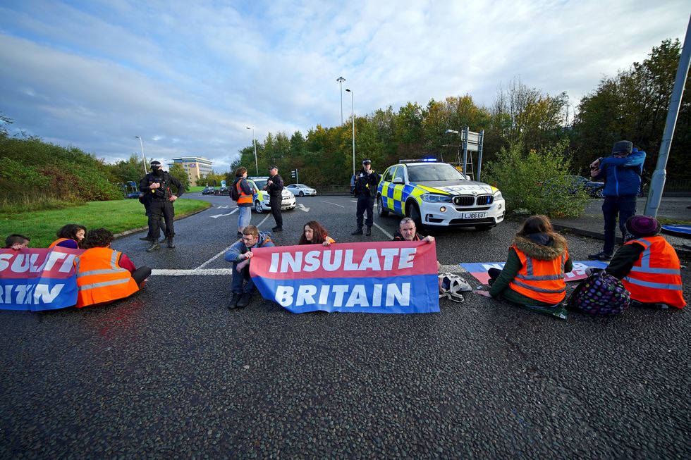 Protesters from Insulate Britain blocking a road near to the Holiday Inn Express Motorway Airport in Manchester. Picture date: Tuesday November 2, 2021.