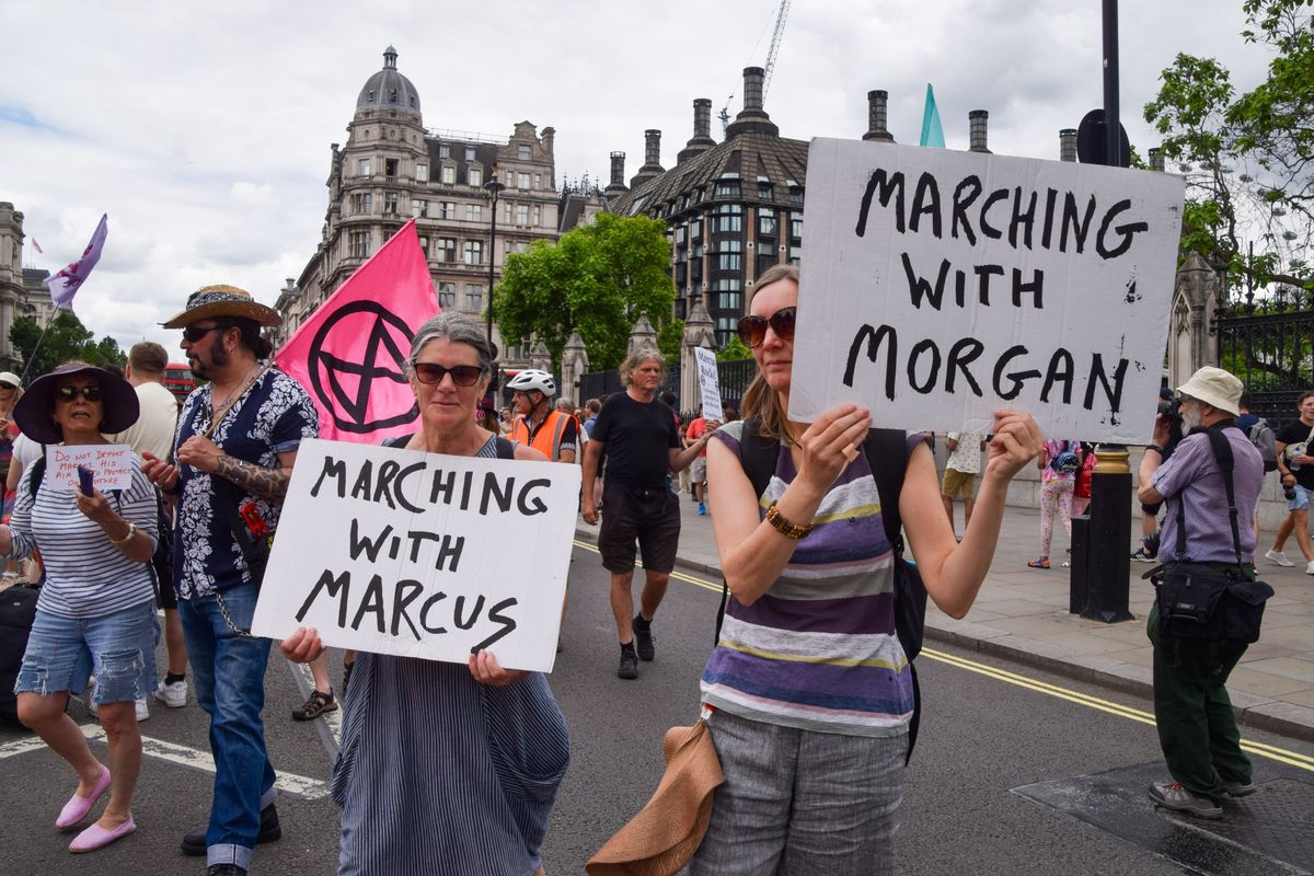 Protesters hold 'Marching with Marcus and Morgan' placards during the demonstration