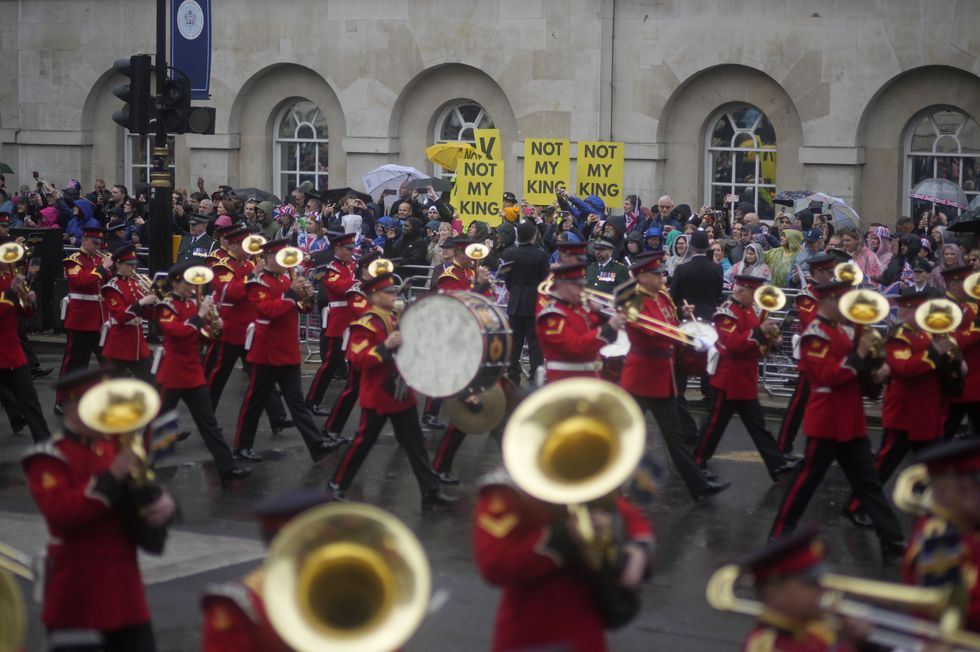Protesters hold up banners following the coronation ceremony of King Charles III and Queen Camilla at Westminster Abbey in London