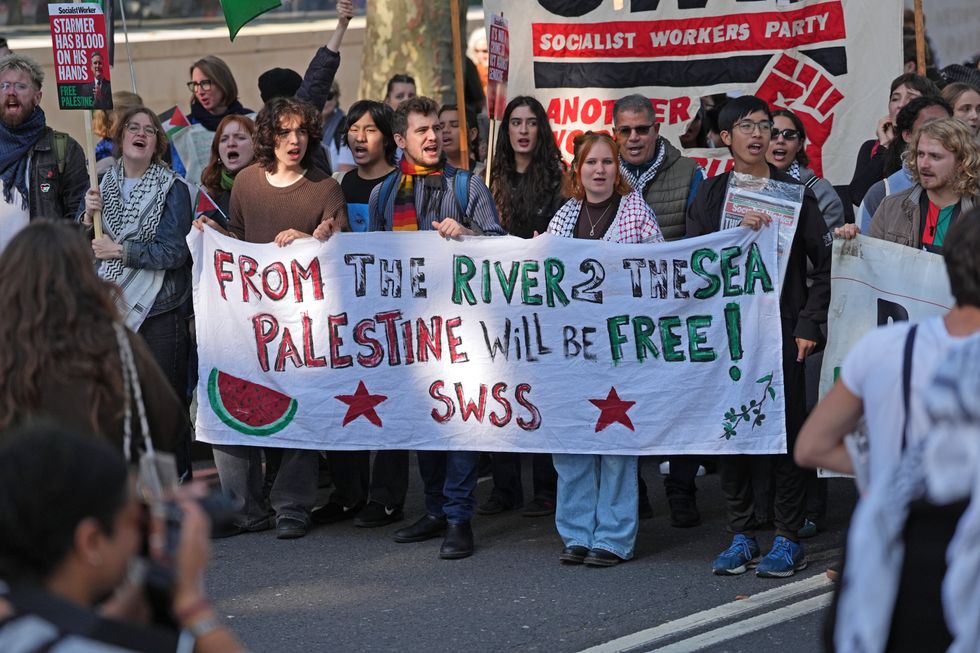 Protesters marching holding a sign reading: 'From the river to the sea, Palestine will be free'\u200b