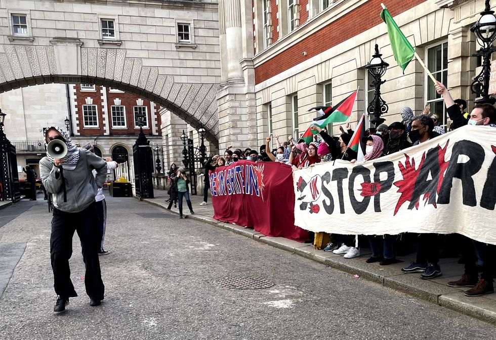 Protesters outside the Department for Business and Trade, one holding a megaphone