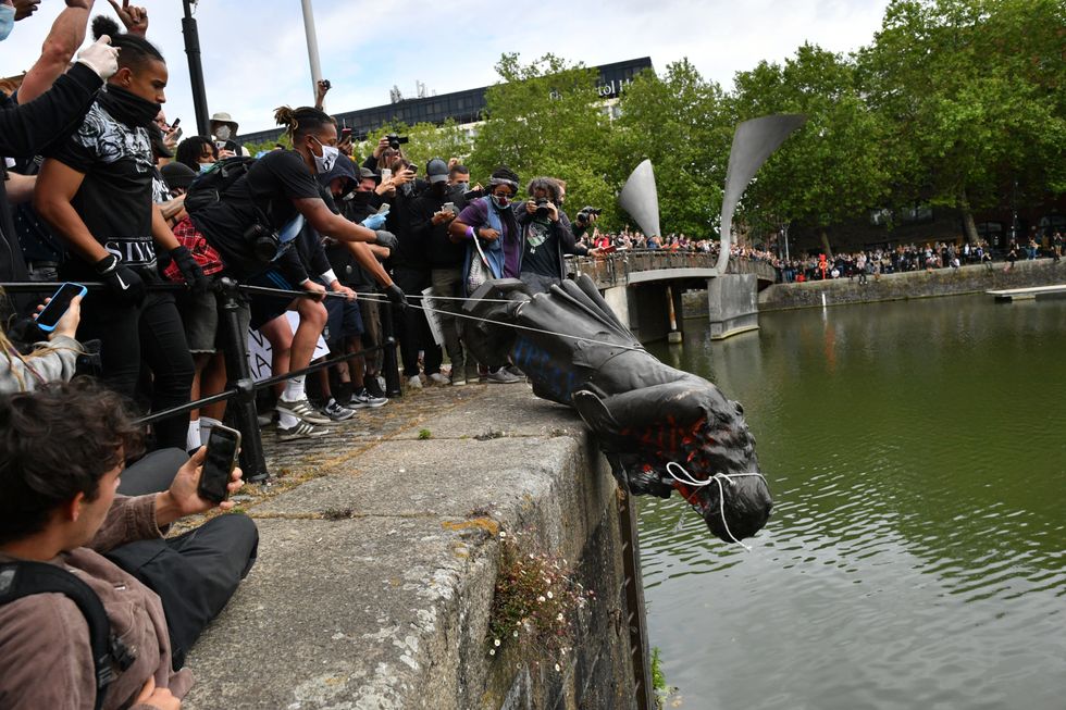 Protesters throwing statue of Edward Colston into Bristol harbour during a Black Lives Matter protest rally. Four people are on trial accused of criminal damage in relation to the toppling of a statue of the slave trader Edward Colston. Rhian Graham, 29, Milo Ponsford, 25, Jake Skuse, 36, and Sage Willoughby, 21, deny charges of criminal damage.