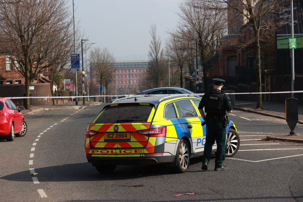 PSNI officers patrol a cordon at the Holy Cross church where emergency services are attending a security alert, which is believed to centre around a hijacked van, close to The Houben Centre, Belfast, which has caused the cancellation of a peacebuilding event attended by the Irish Foreign Affairs Minister. Simon Coveney was speaking at the event organised by the John and Pat Hume Foundation in Belfast when he abruptly ended his speech and was ushered from the room. Picture date: Friday March 25, 2022.