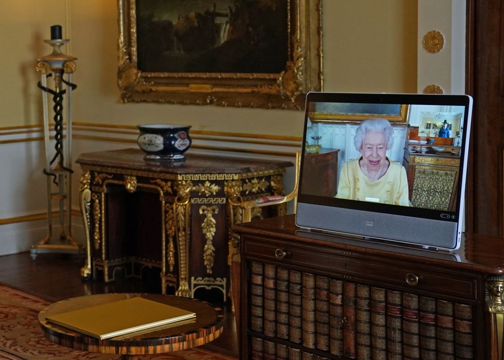 Queen Elizabeth II appears on a screen via videolink from Windsor Castle, where she is in residence.