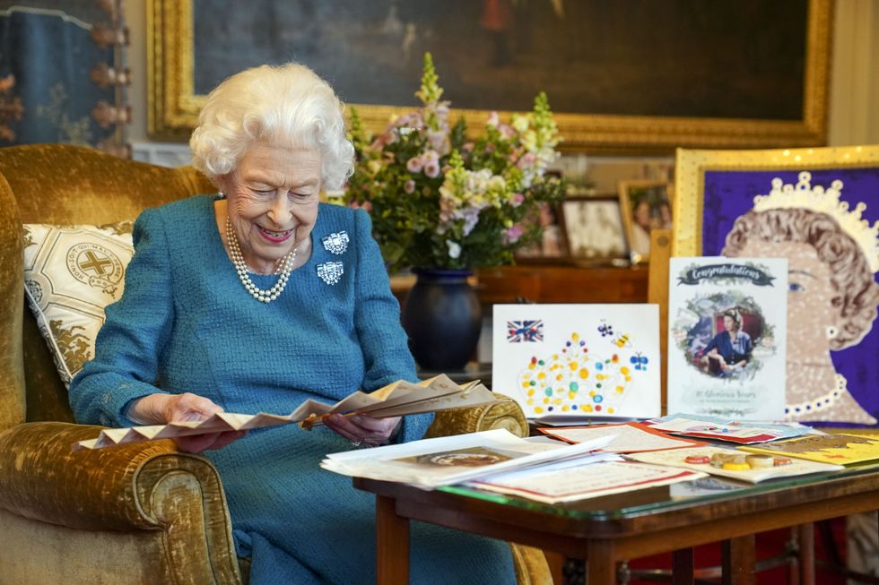 Queen Elizabeth II looks at a fan as she views a display of memorabilia from her Golden and Platinum Jubilees in the Oak Room at Windsor Castle. Issue date: Friday February 4, 2022.