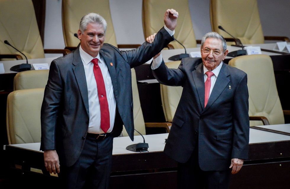 Raul Castro (right) raising the arm of his successor Miguel Diaz-Canel\u200b (left)