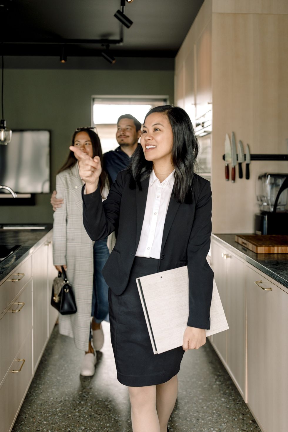 Real estate agent showing potential buyers around a house