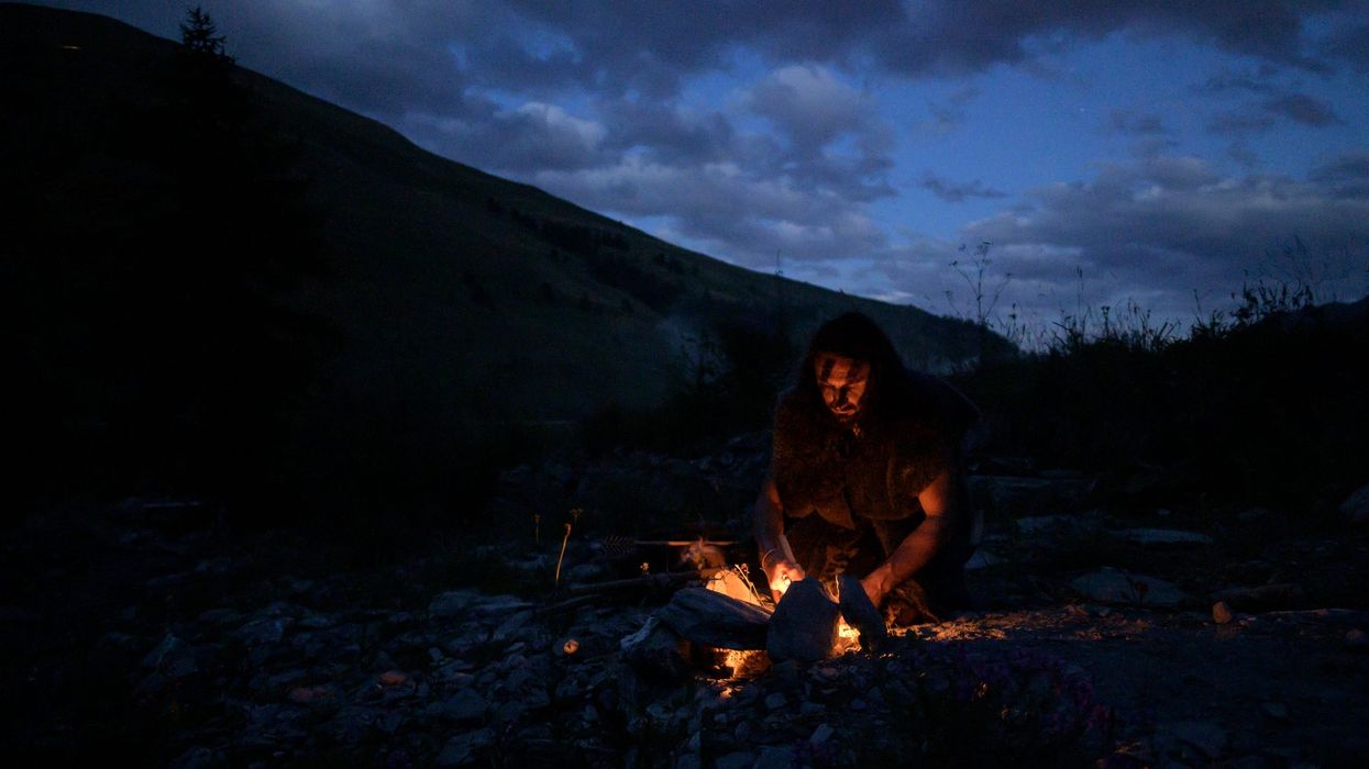 Recreation of a caveman lighting a fire