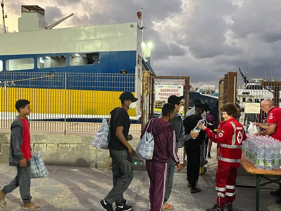 Red Cross workers give migrants water