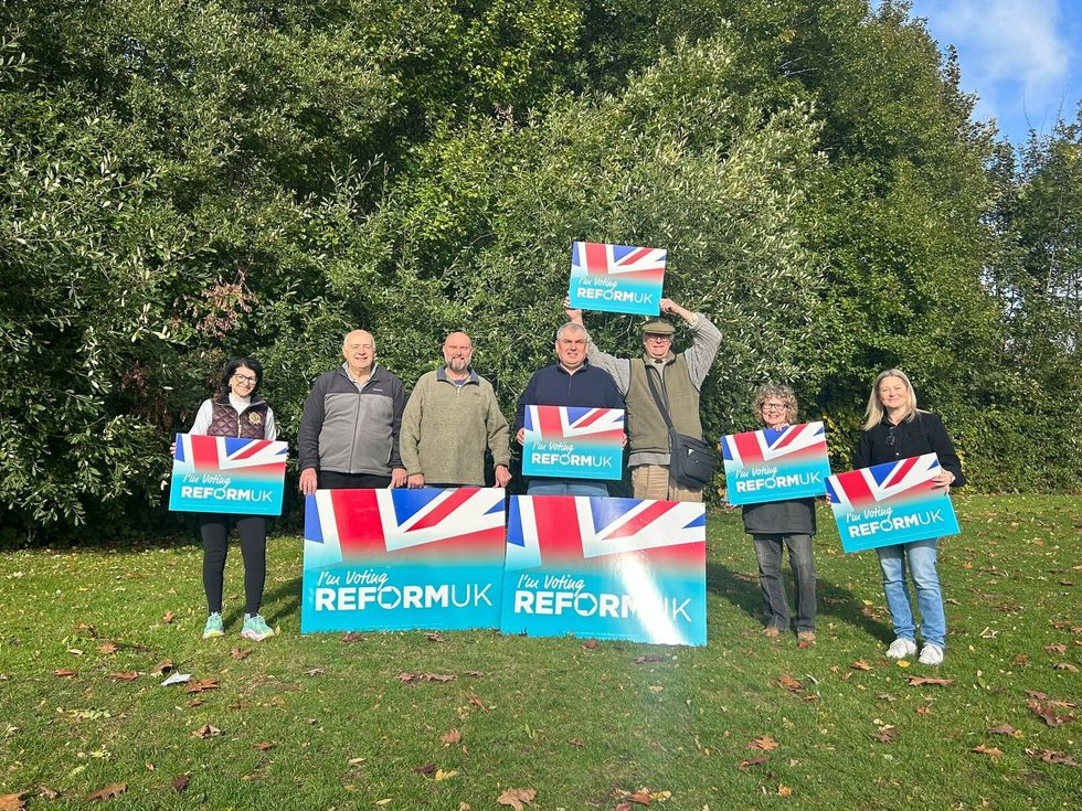 Reform UK campaigners hold signs alongside Lloyds and Corby Village candidate Lee Duffy
