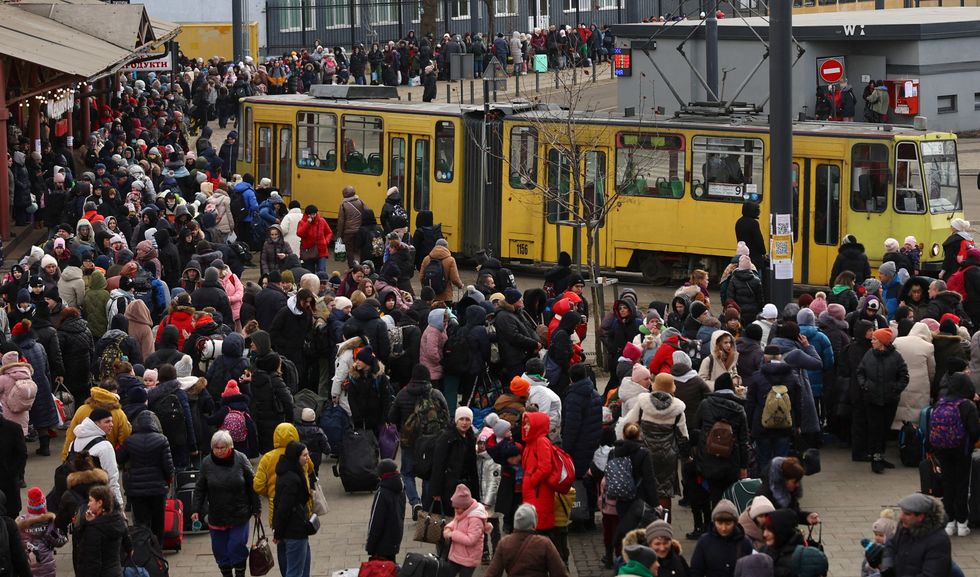 Refugees fleeing the ongoing Russian invasion of Ukraine wait for hours to board a train to Poland, outside the train station in Lviv, Ukraine, March 8, 2022. REUTERS/Kai Pfaffenbach TPX IMAGES OF THE DAY